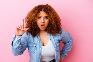 Young latin curvy woman isolated on pink background having an idea, inspiration concept.
