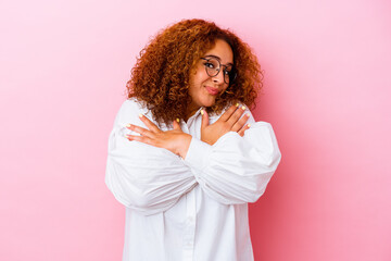 Young latin curvy woman isolated on pink background hugs, smiling carefree and happy.