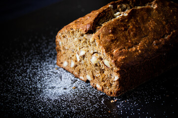 A close up of a loaf of banana bread with surrounding sugar.
