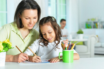 little cute girl with mother drawing