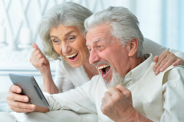 portrait of a happy senior couple using tablet