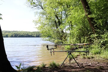 Fishing hobby. Fishing rods on a stand by the lake. Fishing stand with fishing rods by the water.