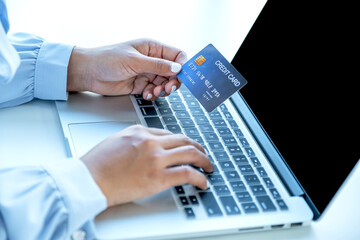 Consumer woman hand holding a mock up credit card, Ready to spending pay online finance shopping according to discount products via laptop from home office