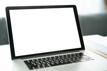 Empty screen on modern laptop computer on the white table in home office.