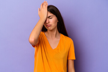 Young caucasian woman isolated on purple background forgetting something, slapping forehead with...