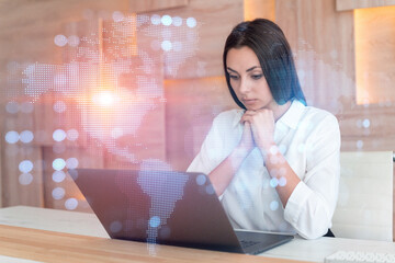Attractive businesswoman in white shirt at workplace working with laptop to hire new employees for international business consulting. HR, social media hologram icons over office background