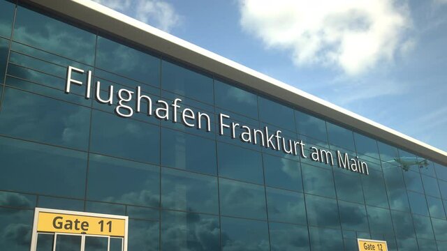 Taking off airplane reflecting in the modern windows with Flughafen Frankfurt am Main or Frankfurt am Main Airport text