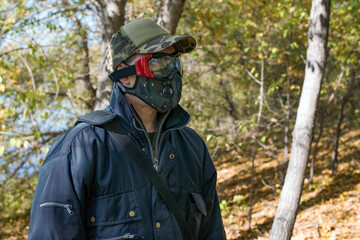 Fototapeta premium A man wearing a respirator mask and protective glasses in the forest at COVID-19 period.