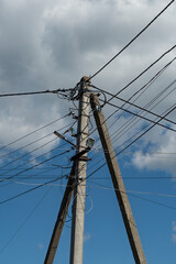 Fototapeta premium Electric pole with wires against the blue sky
