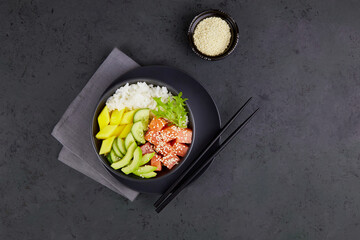 Poke bowl with salmon, rice, avocado, cucumber, mango, greens. Hawaiian ahi, diet food with fish. 