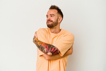 Young tattooed caucasian man isolated on white background hugs, smiling carefree and happy.