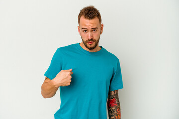 Young tattooed caucasian man isolated on white background surprised pointing with finger, smiling broadly.