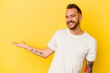 Young tattooed caucasian man isolated on yellow background showing a welcome expression.