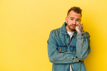 Fototapeta premium Young tattooed caucasian man isolated on yellow background who feels sad and pensive, looking at copy space.