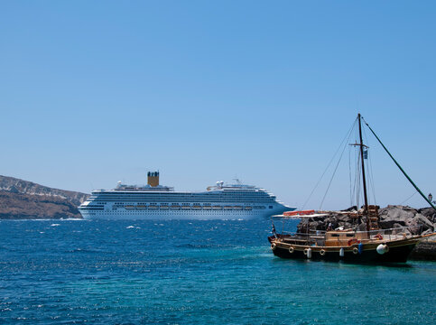 Cruise ships in Greece sailing in the caldera of the island of Santorini. In the background the blue sky and the Aegean Sea