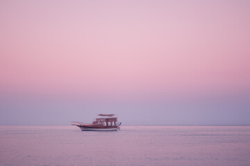 A boat on a surface of The Mediterranean Sea at sunrise