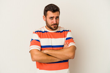 Young caucasian man isolated on white background suspicious, uncertain, examining you.