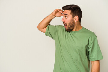 Obraz premium Young caucasian man isolated on white background looking far away keeping hand on forehead.