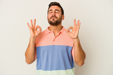 Young caucasian man isolated on white background relaxes after hard working day, she is performing yoga.