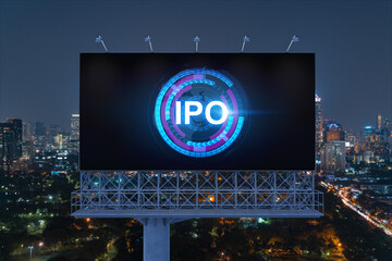 IPO icon hologram on road billboard over night panorama city view of Bangkok. The hub of initial...