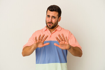 Young caucasian man isolated on white background rejecting someone showing a gesture of disgust.