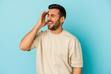 Young caucasian man isolated on blue background joyful laughing a lot. Happiness concept.