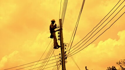 An electrician working at a newly installed utility pole - connects a new power line.