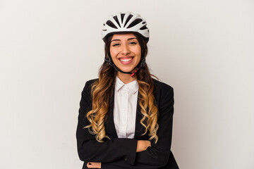 Young mexican woman riding a bicycle to work isolated on white background laughing and having fun.