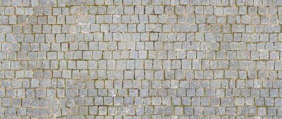 Granite cobblestoned pavement background. Stone pavement texture. Abstract background of cobblestone pavement close-up. Seamless texture. Perfect tiled on all sides.