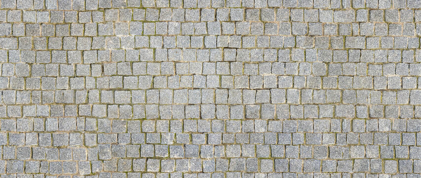 Granite cobblestoned pavement background. Stone pavement texture. Abstract background of cobblestone pavement close-up. Seamless texture. Perfect tiled on all sides.