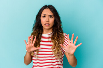 Young mexican woman isolated on blue background rejecting someone showing a gesture of disgust.