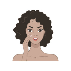 A beautiful girl with dark curly hair applies a moisturizer to her face. Skin care