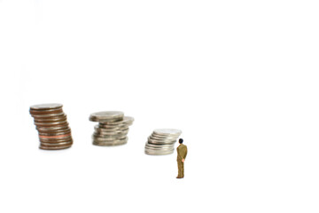 Miniature figures businessman stand on coins, on the white backgroud.