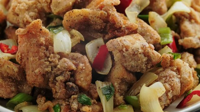 Stir fry chinese salt and pepper chicken with red, green chilli, onion, spring onion. rotating video