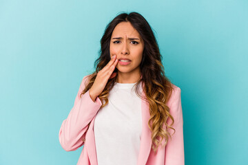 Young mexican woman isolated on blue background having a strong teeth pain, molar ache.