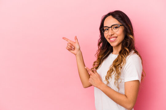 Young mexican woman isolated on pink background excited pointing with forefingers away.