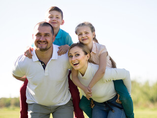 children riding their parents in the park