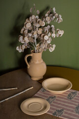 A composition of sand plates on a wooden table with green accessories in a boho style