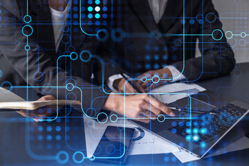 Two information technology specialist brainstorming on project to create a new approach to develop software to improve business service. Technological icons over the table with document.