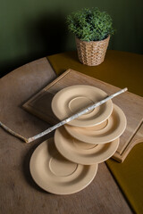 A composition of sand plates on a wooden table with green accessories in a boho style