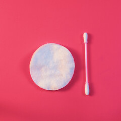 Cotton swab and cotton pad as a symbol of hygiene and body care on a pink background