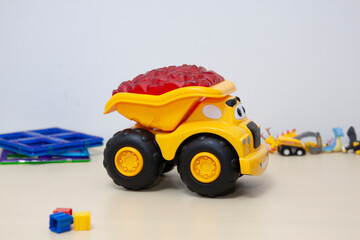 The yellow dump truck toy on the table.