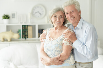 cheerful senior couple embracing at home