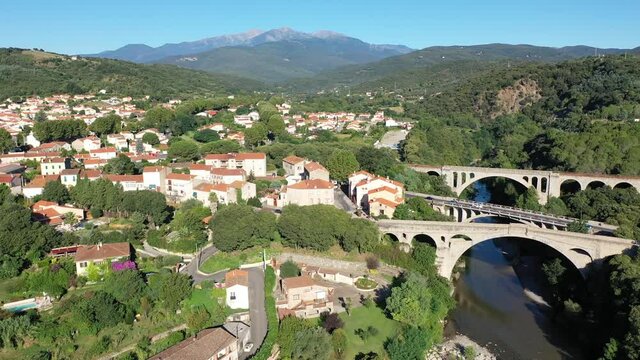 General view from drone of Ceret town on banks of river Tech in foothills of Pyrenees mountains in summer, France