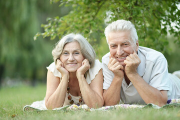 portrait of beautiful senior couple lying in park