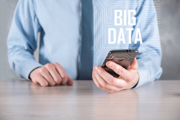 Businessman in a suit on a dark background holds the inscription BIG DATA. Storage Network Online Server Concept.Social network or business analytics representation