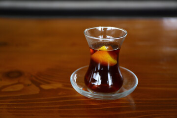 Sliced lemon in hot tea. Thin belly, tea cup traditional serving style in Turkey for hot black tea. Black tea serving style. Tea and coffee shop in Istanbul.