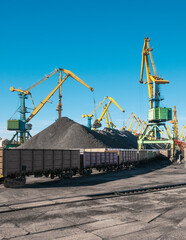 Fototapeta na wymiar huge amount of coal in the Murmansk commercial seaport. Coal is delivered here in industrial wagons, distributed throughout the port, unloaded, and then loaded onto sea dry cargo ships.