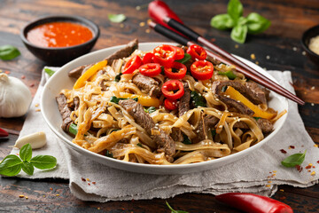 Stir fry Beef Chow Fun with rice noodles, bean sprouts, spring onions and chili.
