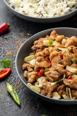 Stir fry chinese salt and pepper chicken with rice in grey bowl